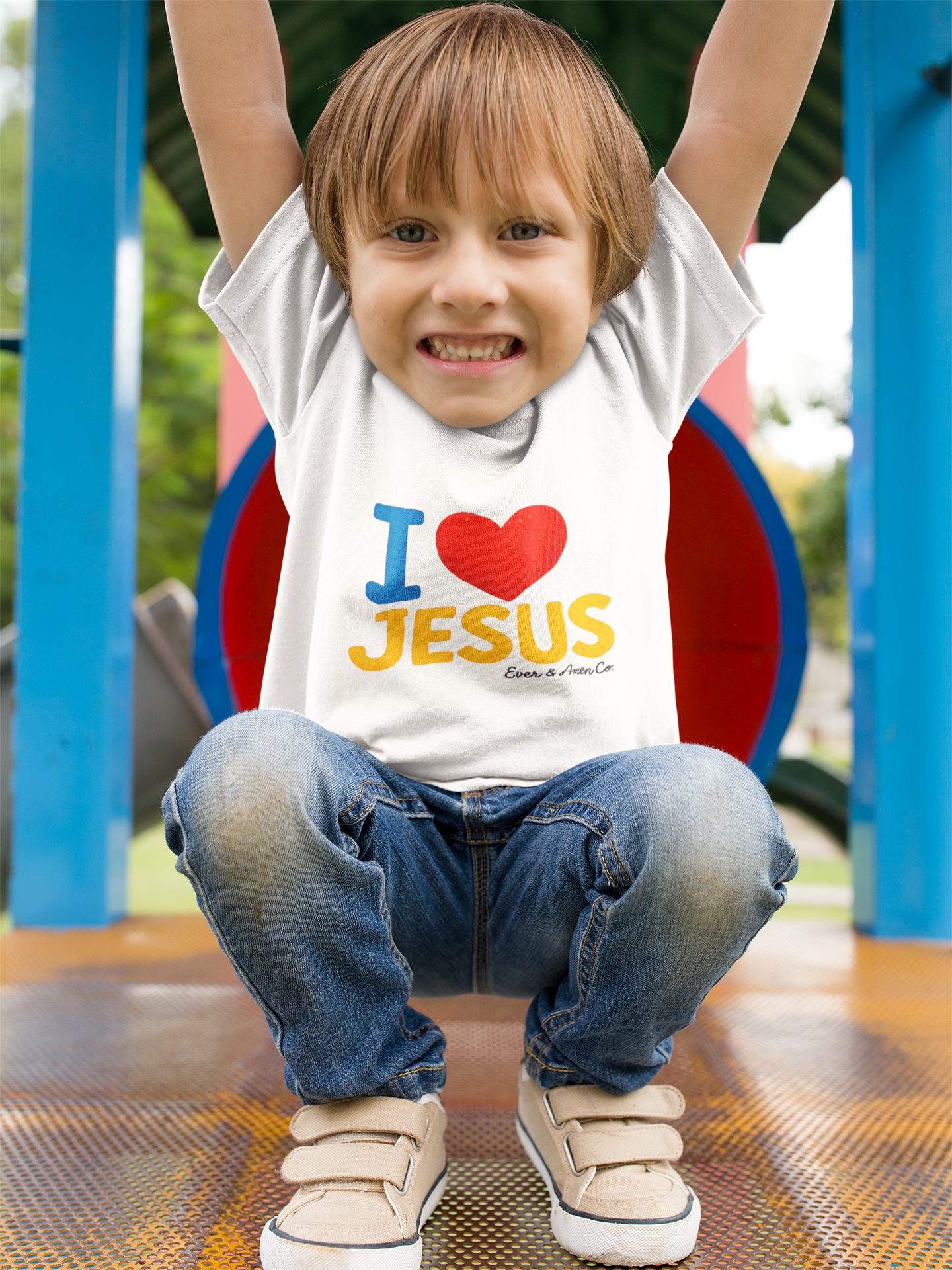 Child wearing a shirt with 'I ❤️ JESUS' on a playground.