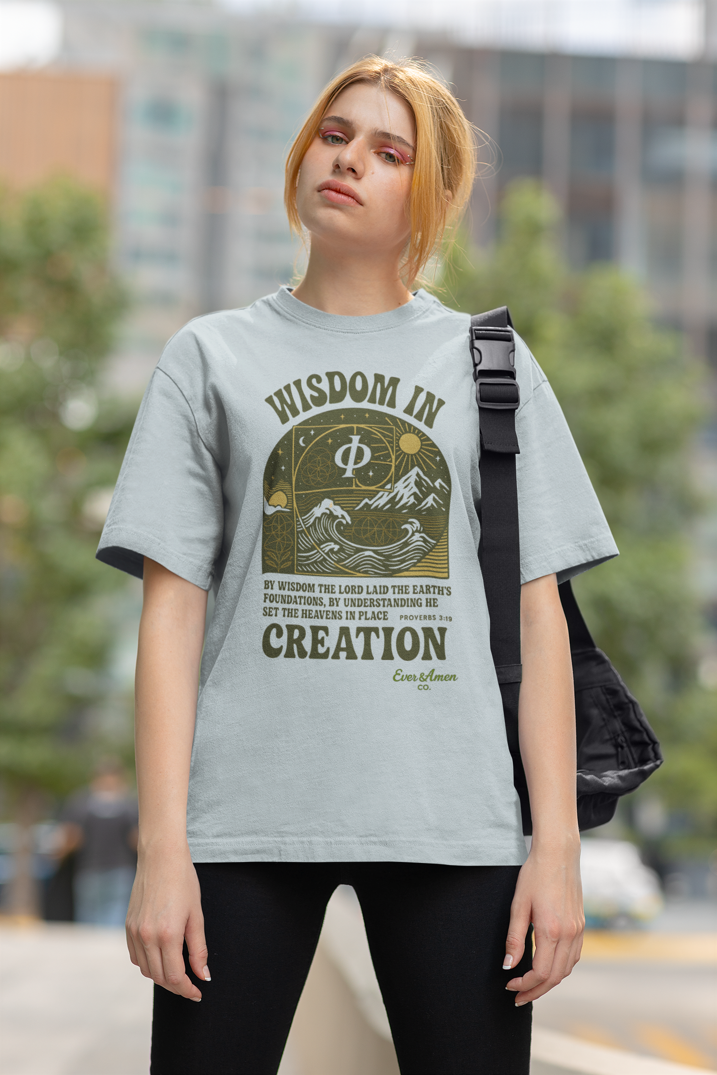 Faith-based oversized tee with sacred geometry and scripture from Proverbs 3:19. Modern Christian design for men and women.